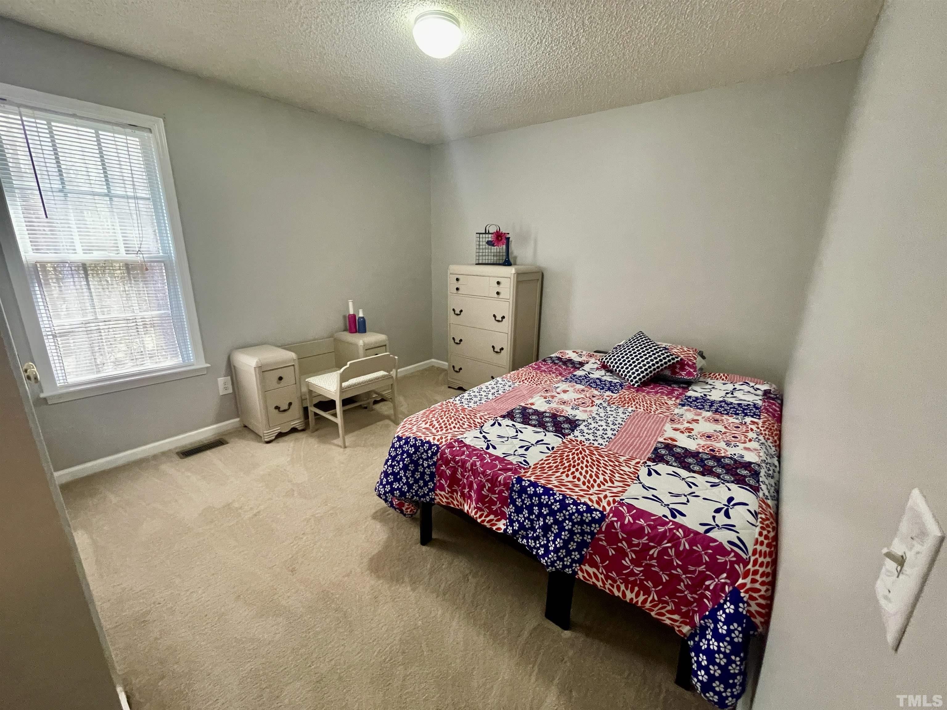 6105 Ruddington Court Willow Spring, NC 27592 - Photo 9 of 18 a bedroom with a bed and a window