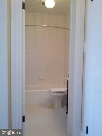 a bathroom with a white toilet and a shower