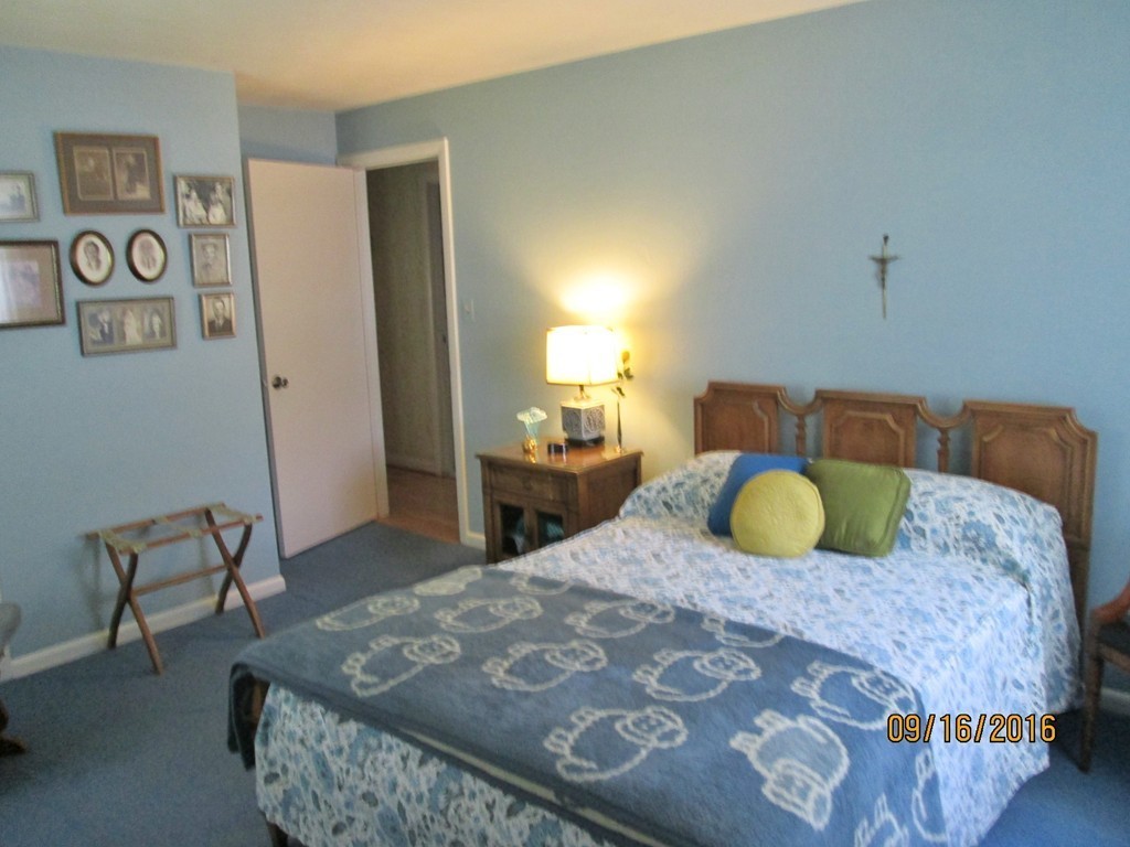 38 Greaney Street Springfield, MA 01104 - Photo 12 of 25 a bedroom with a bed and dresser with mirror