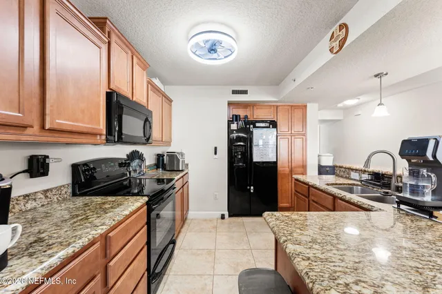 a kitchen with granite countertop a stove and a sink