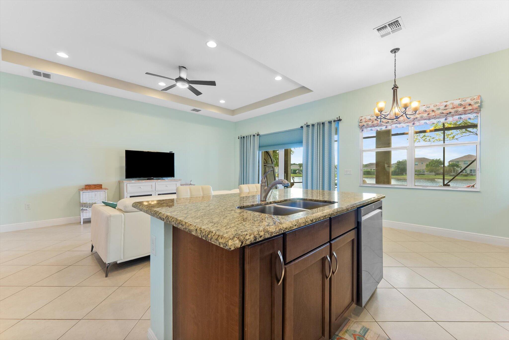 2930 Bellarosa Circle Royal Palm Beach, FL 33411 - Photo 11 of 36 a dining hall with stainless steel appliances granite countertop a sink dishwasher and a flat screen tv