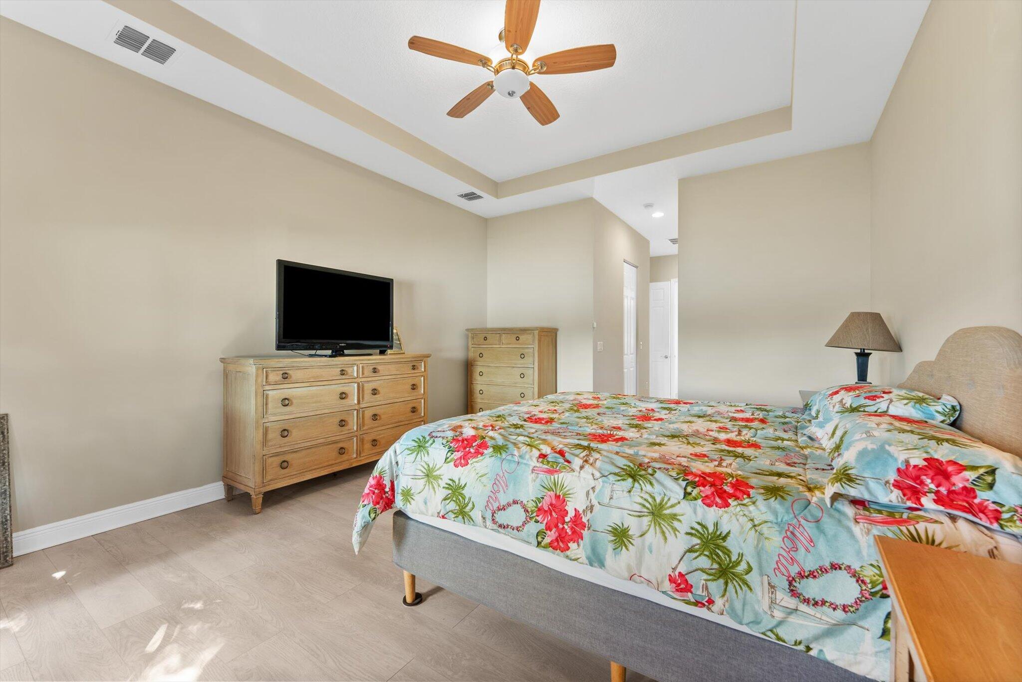 2930 Bellarosa Circle Royal Palm Beach, FL 33411 - Photo 13 of 36 a bedroom with a bed and flat tv screen on the dresser