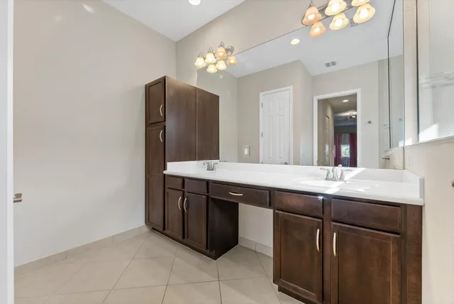 a bathroom with a granite countertop sink a large mirror and a window