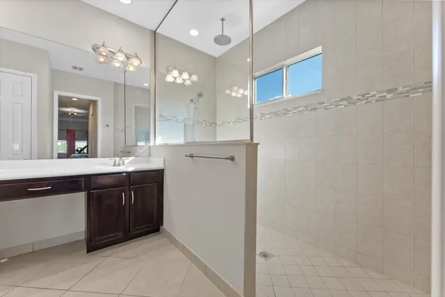 a large bathroom with a sink a large mirror and a shower