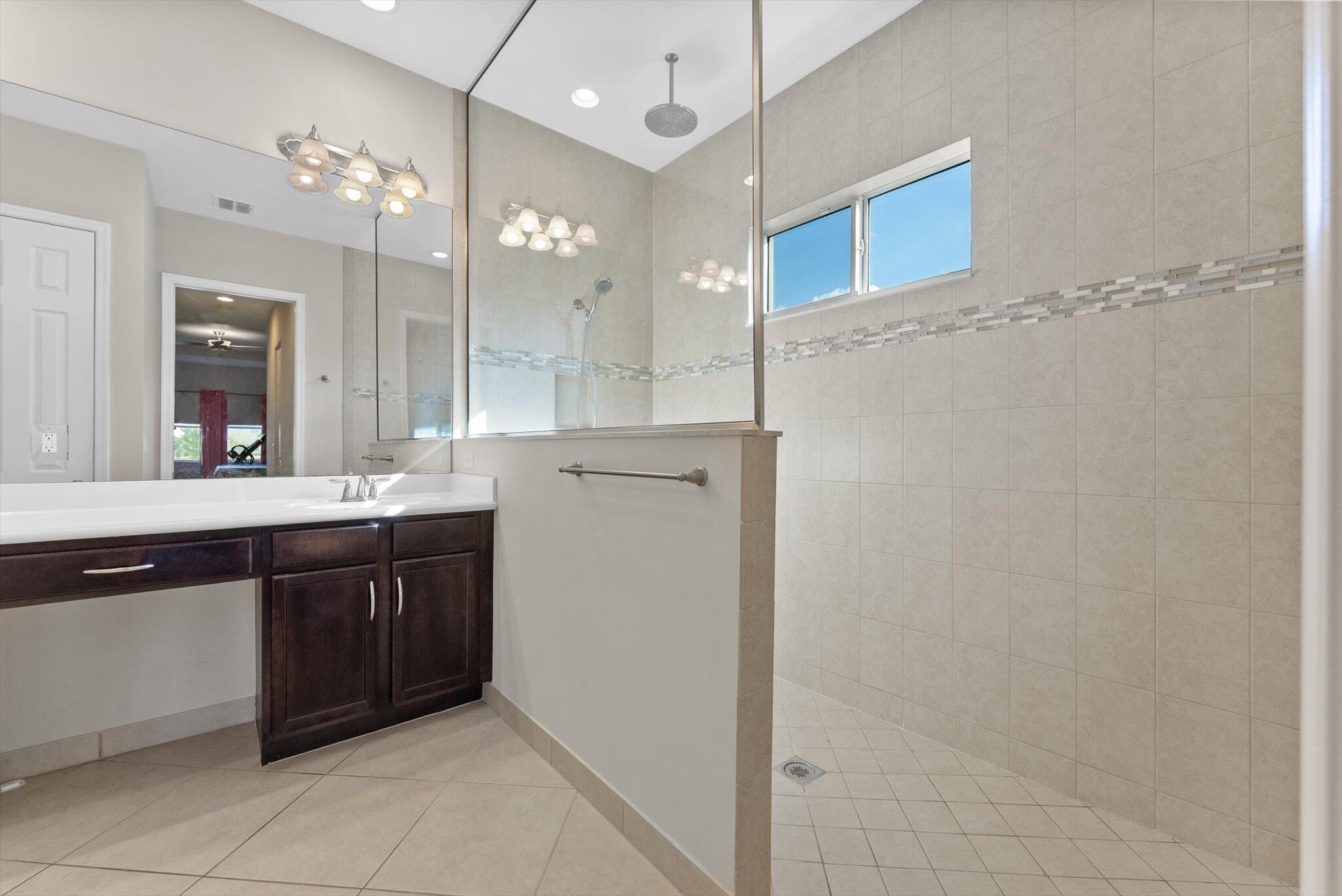 2930 Bellarosa Circle Royal Palm Beach, FL 33411 - Photo 15 of 36 a large bathroom with a sink a large mirror and a shower