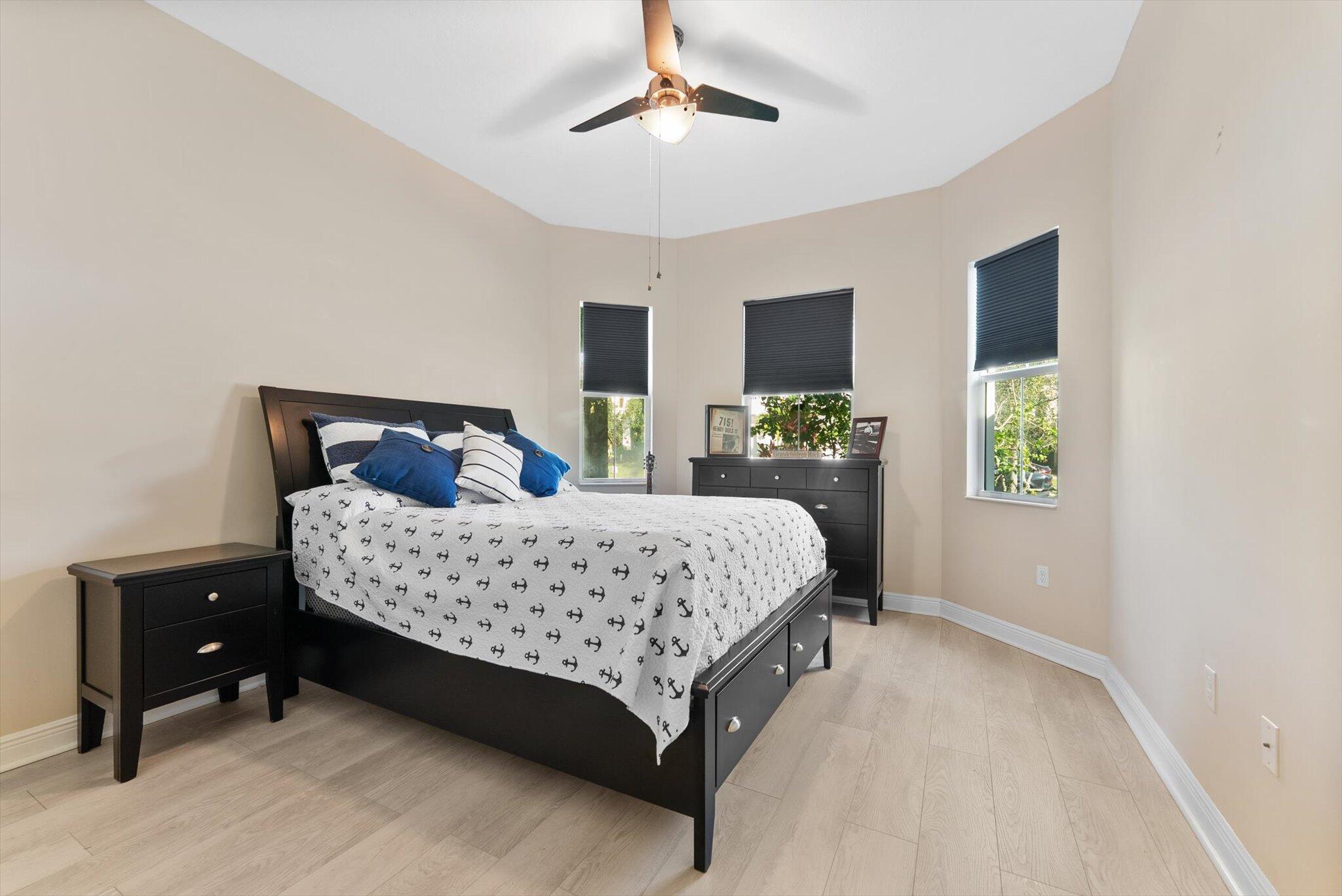 2930 Bellarosa Circle Royal Palm Beach, FL 33411 - Photo 19 of 36 a bedroom with a bed and a chandelier