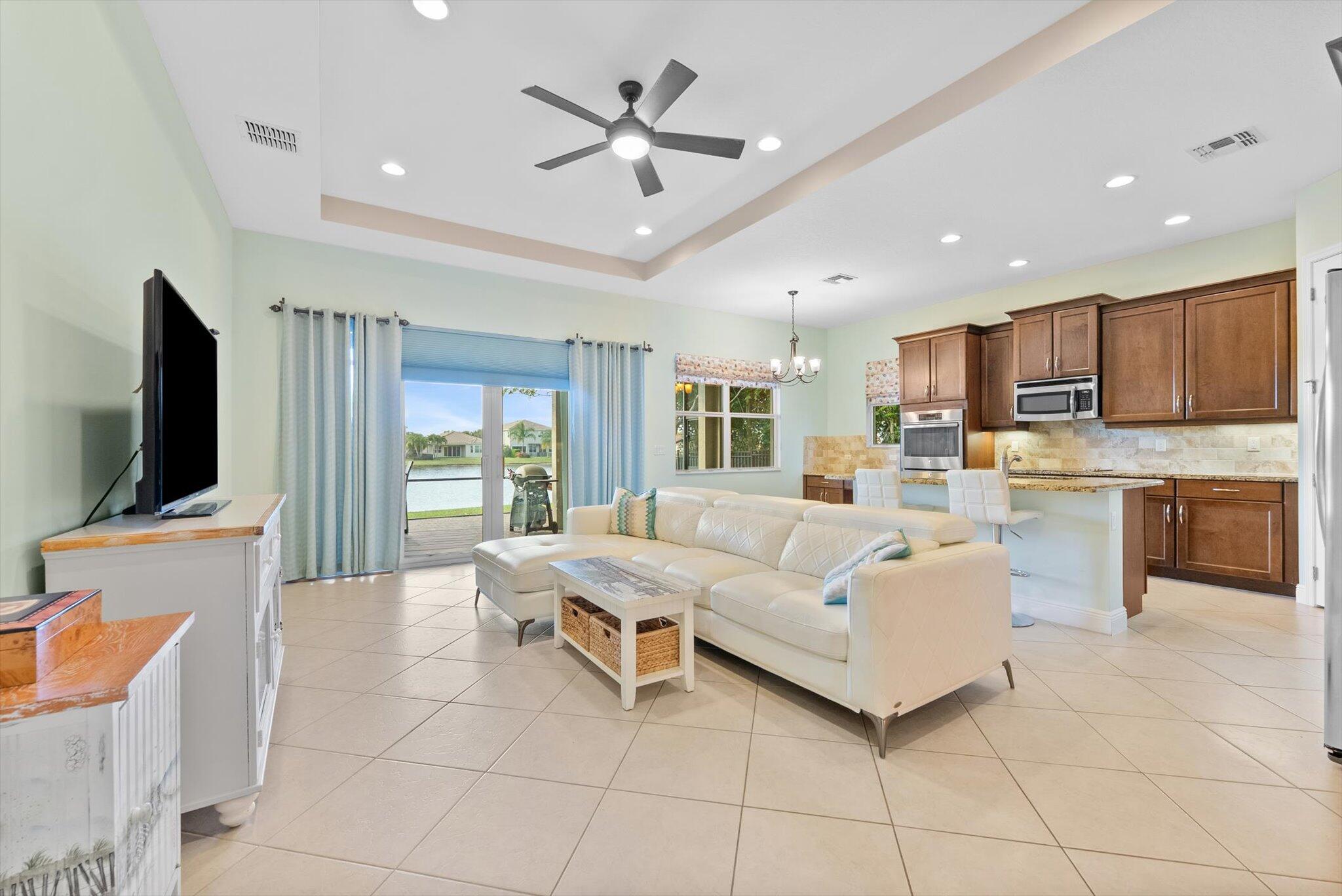 2930 Bellarosa Circle Royal Palm Beach, FL 33411 - Photo 5 of 36 a living room with furniture a flat screen tv and kitchen view