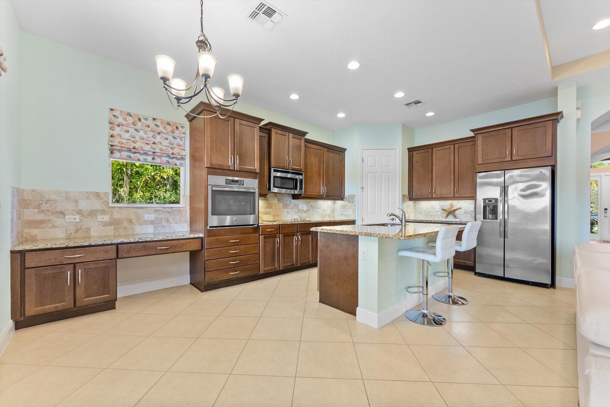 2930 Bellarosa Circle Royal Palm Beach, FL 33411 - Photo 6 of 36 a kitchen with stainless steel appliances granite countertop a sink refrigerator and cabinets