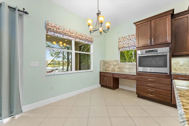 a kitchen with stainless steel appliances granite countertop a stove a sink dishwasher and microwave with wooden floor