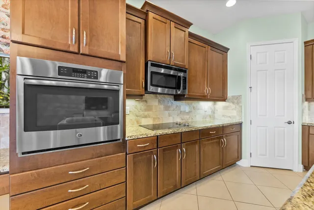 a kitchen with granite countertop white cabinets stainless steel appliances and a sink