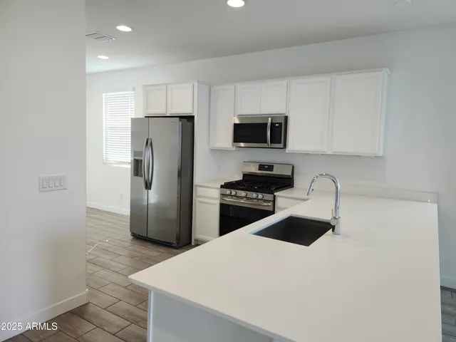 a kitchen with stainless steel appliances a refrigerator stove microwave and sink