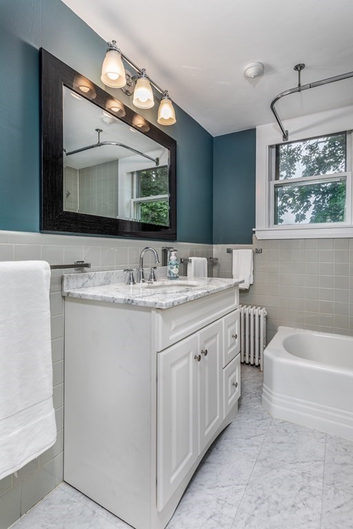3 Lattimer Street Marblehead, MA 01945 - Photo 35 of 42 a bathroom with a double vanity sink a large mirror and bathtub