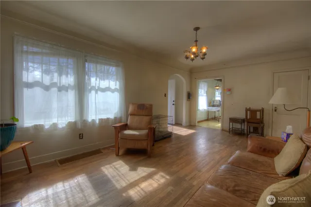 a living room with furniture a chandelier and a window