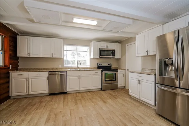 a kitchen with a refrigerator stove top oven and sink