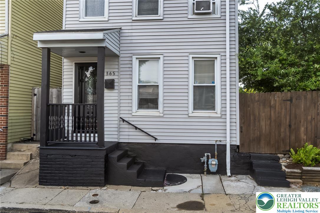 365 Rock Street Easton, PA 18042 - Photo 1 of 50 A classic facade showcasing gray siding, a welcoming covered porch, and secure wooden fencing.