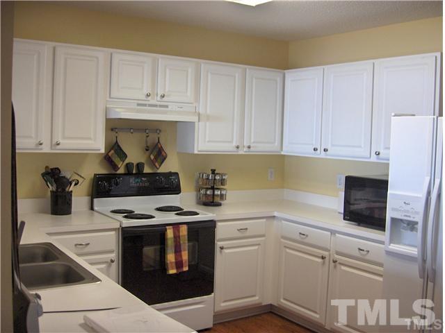4501 Nightfall Court Durham, NC 27713 - Photo 4 of 11 a kitchen with white cabinets and appliances