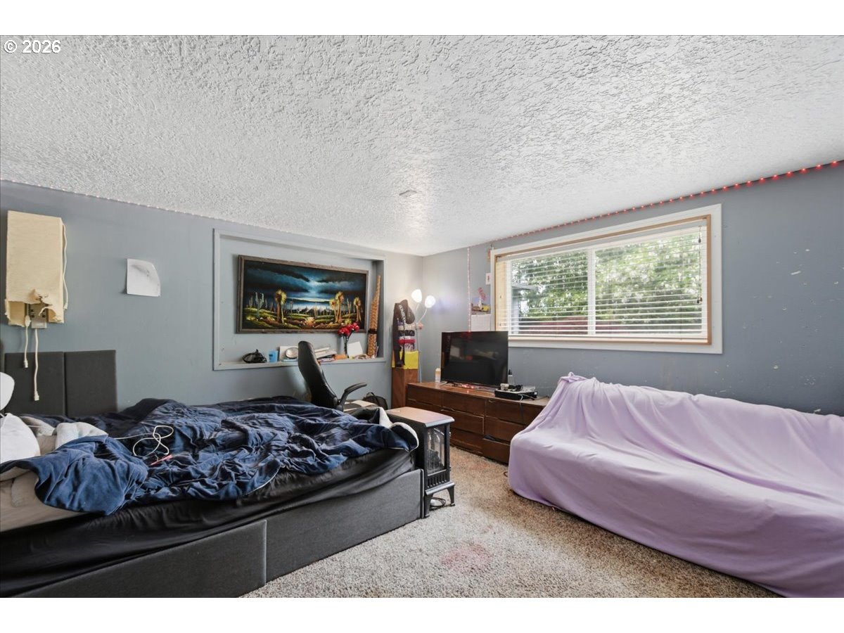 3287 Olive Way Longview, WA 98632 - Photo 11 of 24 a bedroom with a large bed couch and a window