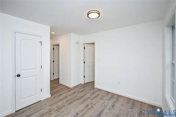 a view of empty room with wooden floor