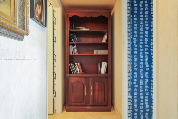 a view of a hallway with wooden floor and a cabinet