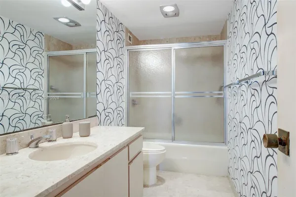 a bathroom with a bathtub sink vanity mirror and toilet