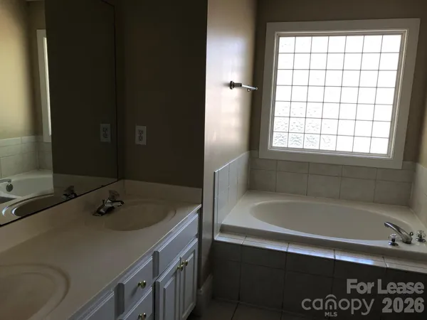 a bathroom with a tub sink and mirror