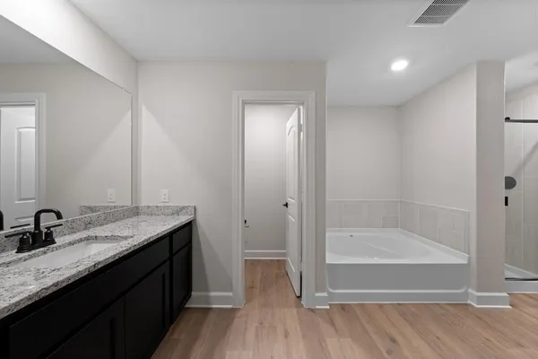 a bathroom with a granite countertop sink a mirror and a bathtub