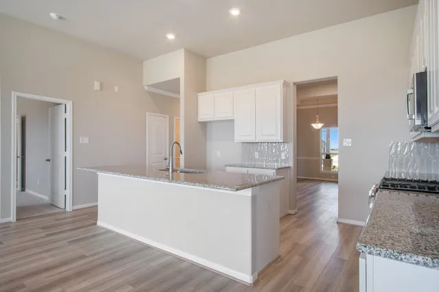 a large kitchen with cabinets and wooden floor