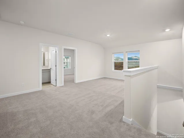a view of empty room with windows and bathroom