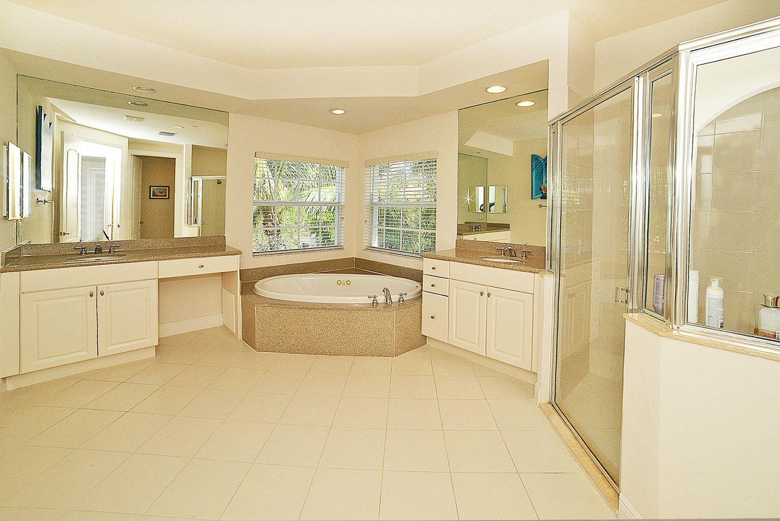 5510 Northeast Trieste Terrace Boca Raton, FL 33487 - Photo 11 of 19 a large bathroom with a tub a sink and a large mirror