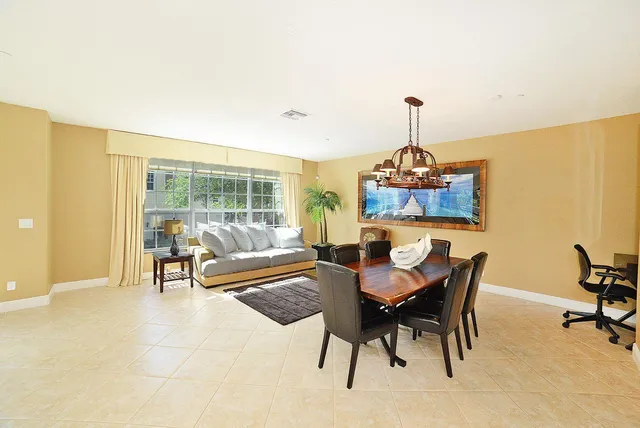 a kitchen with stainless steel appliances kitchen island granite countertop a refrigerator a stove a microwave oven a dining table and chairs with wooden floor