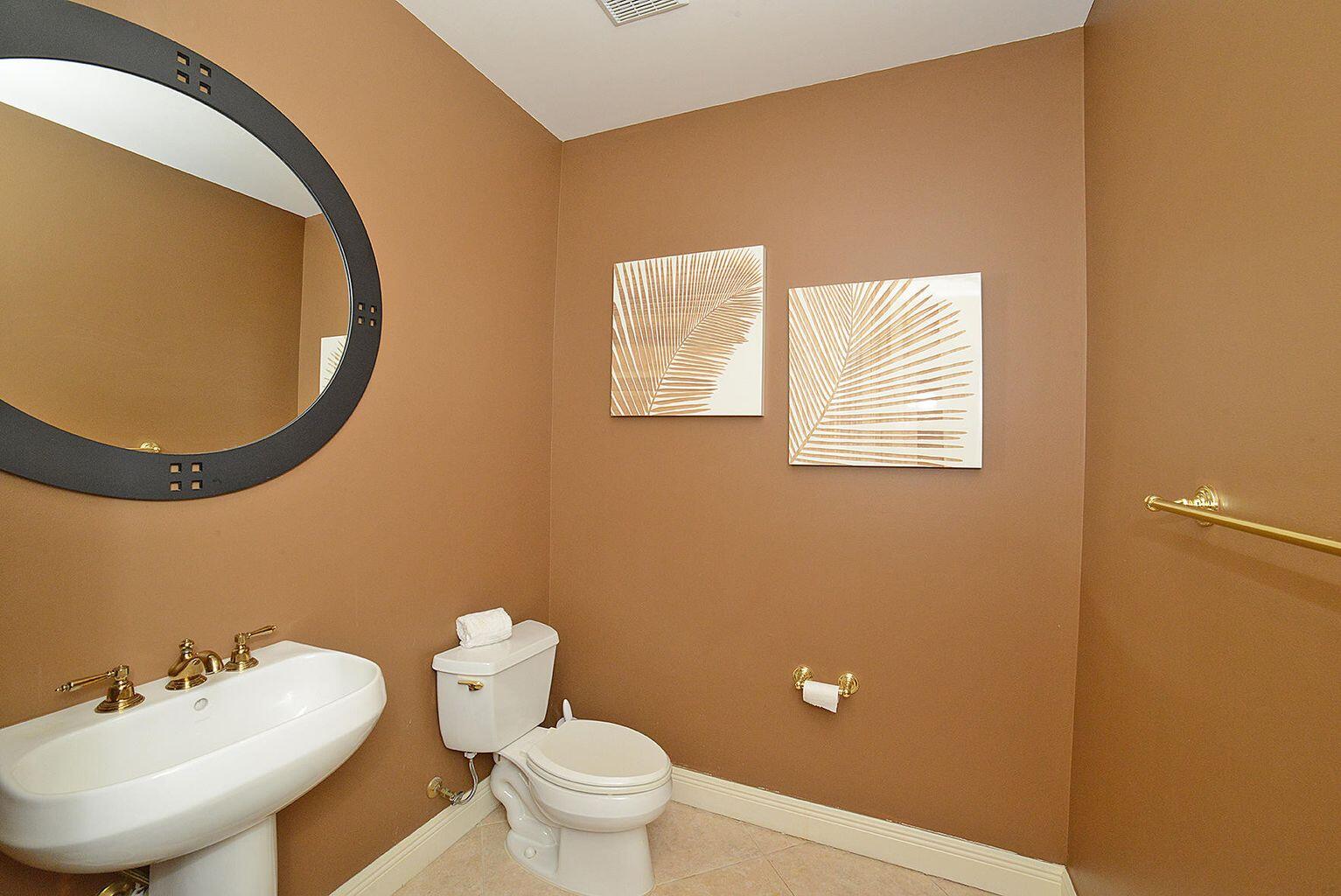 5510 Northeast Trieste Terrace Boca Raton, FL 33487 - Photo 9 of 19 a bathroom with a toilet a sink and mirror
