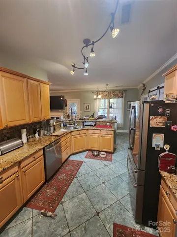 a kitchen with stainless steel appliances kitchen island granite countertop a refrigerator a stove and a sink