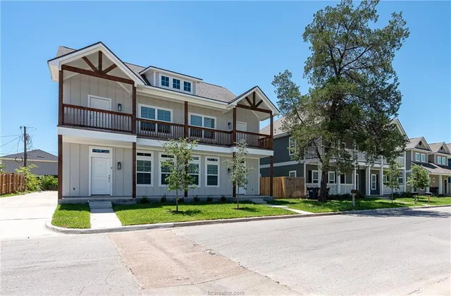 a view of a white house with a big yard and large trees