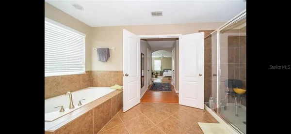 a spacious bathroom with a tub shower and a sink