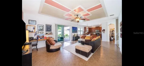 a living room with furniture a chandelier and a wooden floor