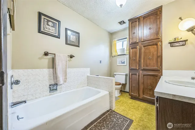 a bathroom with a tub a sink and a large mirror