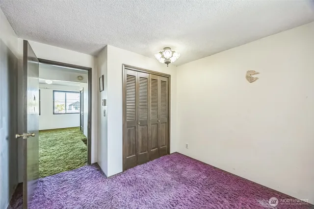 an empty room with windows and closet