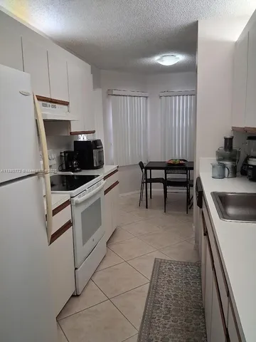 a kitchen with a stove a sink and a refrigerator