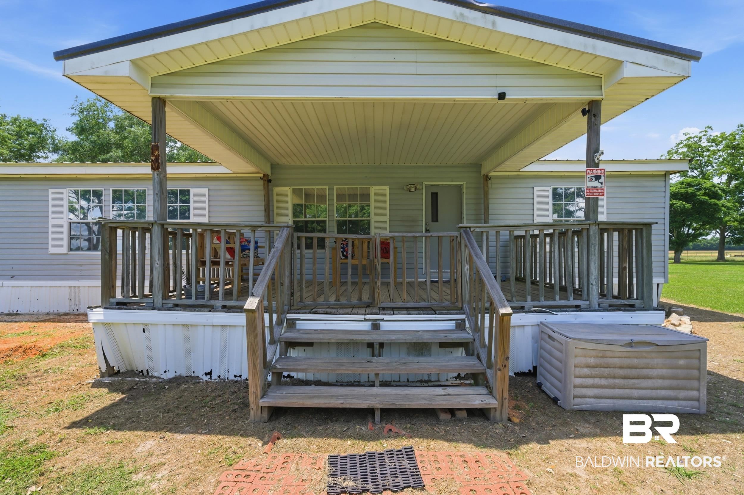 926 Tumbling Lane Atmore, AL 36502 - Photo 5 of 56 Covered front porch with wood railings and steps