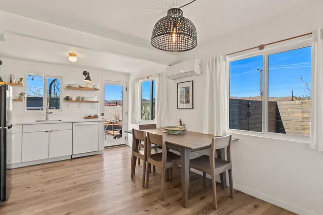 a kitchen with stainless steel appliances a dining table chairs and stove