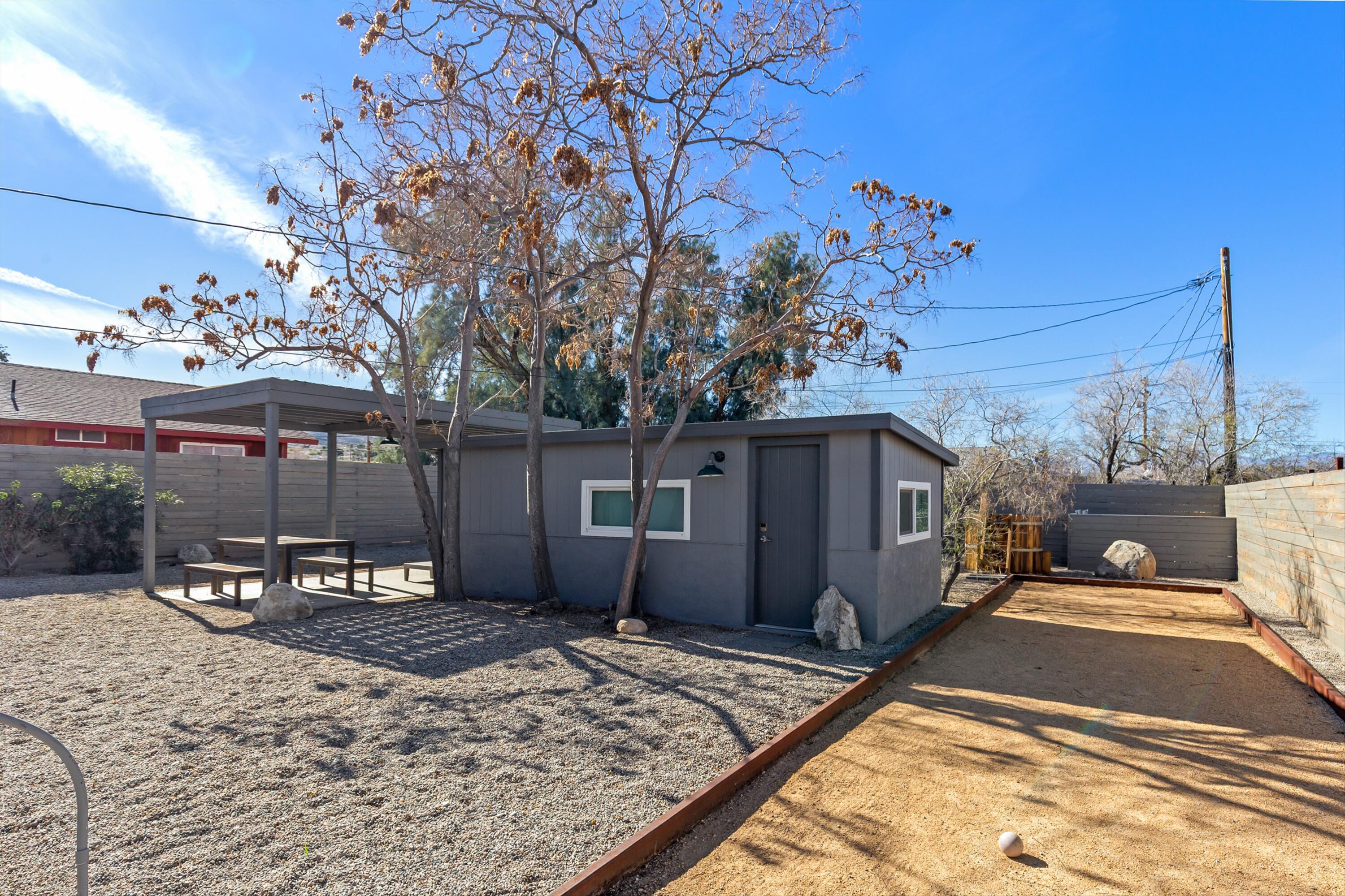 62010 El Reposo Circle Joshua Tree, CA 92252 - Photo 18 of 28 a patio with a table and chairs and potted plants