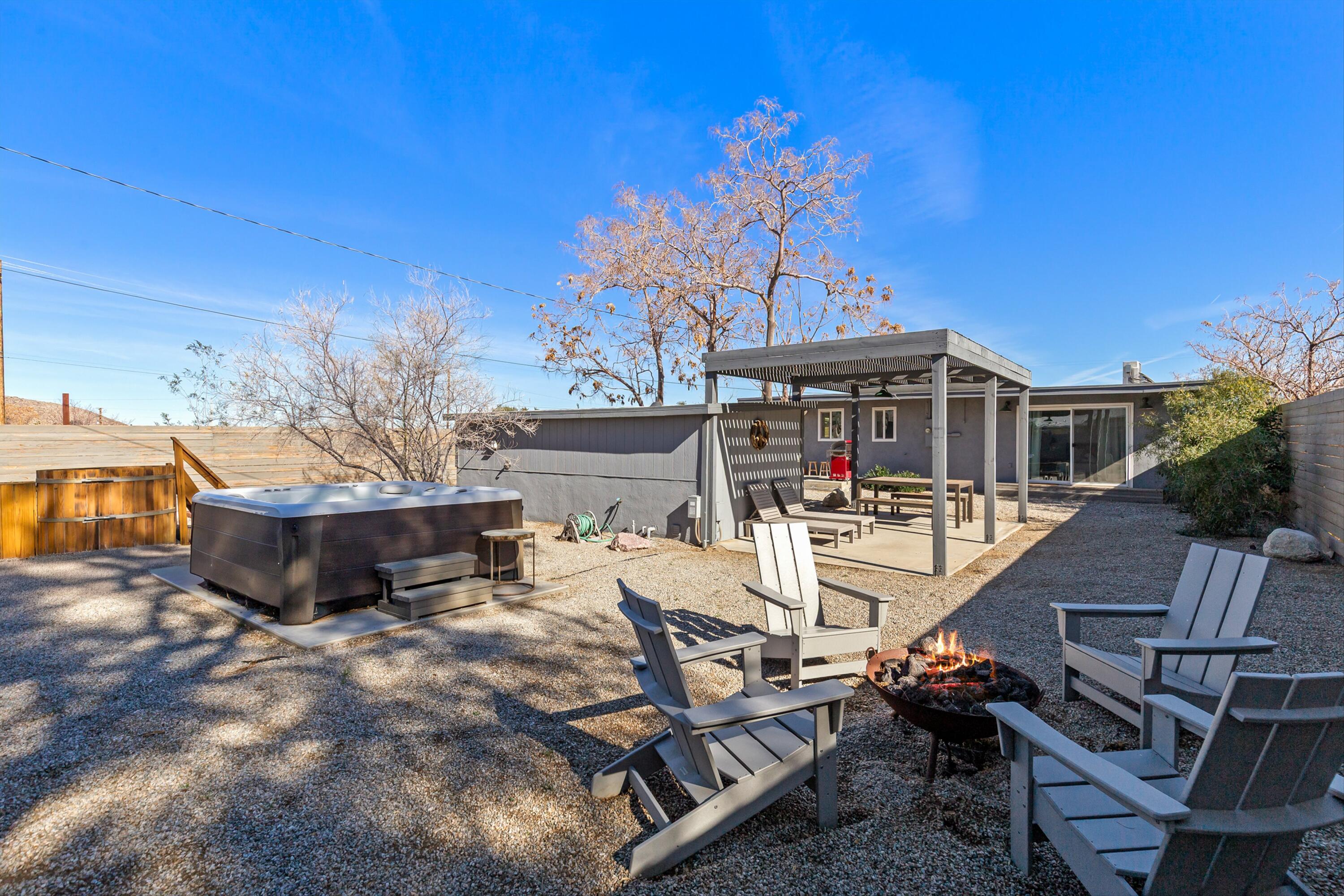 62010 El Reposo Circle Joshua Tree, CA 92252 - Photo 23 of 28 a view of a patio with table and chairs with wooden floor and fence