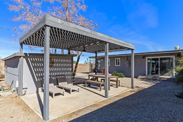 a view of a patio with table and chairs with wooden floor and fence