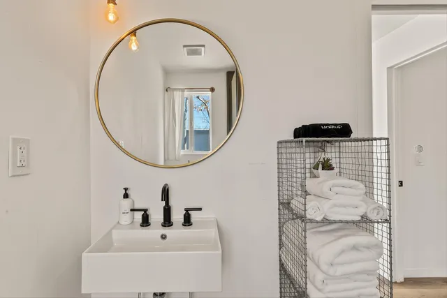 a bathroom with a sink a mirror and a shower