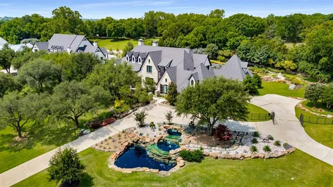 an aerial view of a house with a garden and lake view
