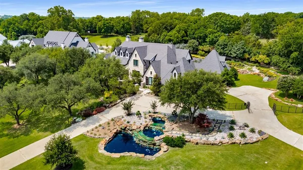 an aerial view of a house with a garden and lake view