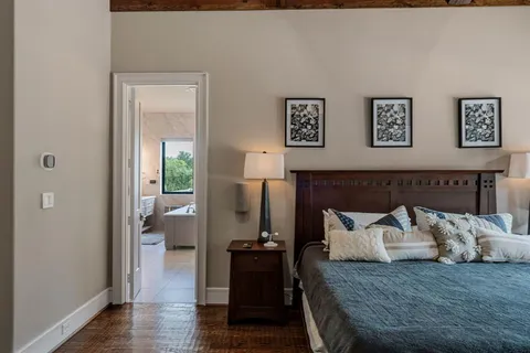a bedroom with a bed and wooden floor