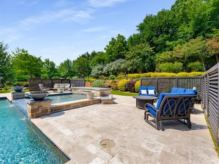 a view of backyard with swimming pool and sitting area