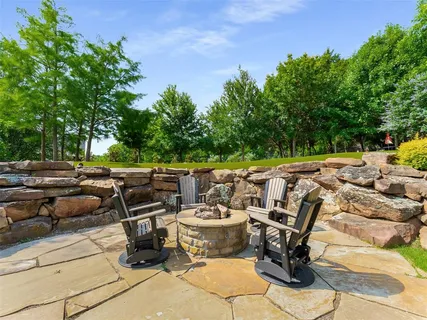 a view of a patio with chairs and potted plants