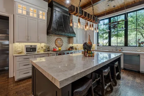 a kitchen with stainless steel appliances granite countertop a sink a stove and a counter space